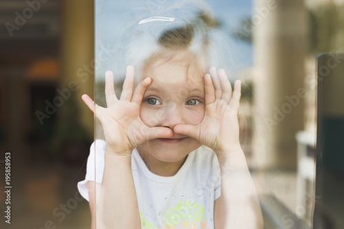 Little girl show emotions in window