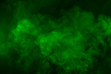Green and yellow smoke in dark background. Texture and desktop picture