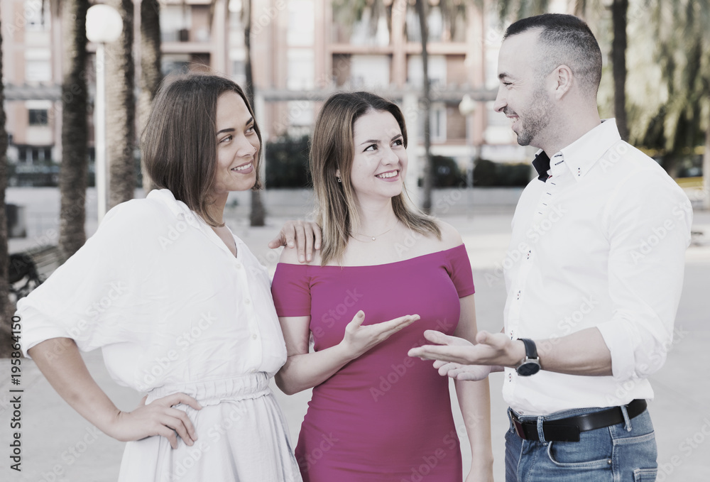 Obraz premium Stranger man is talking with young females who are resting