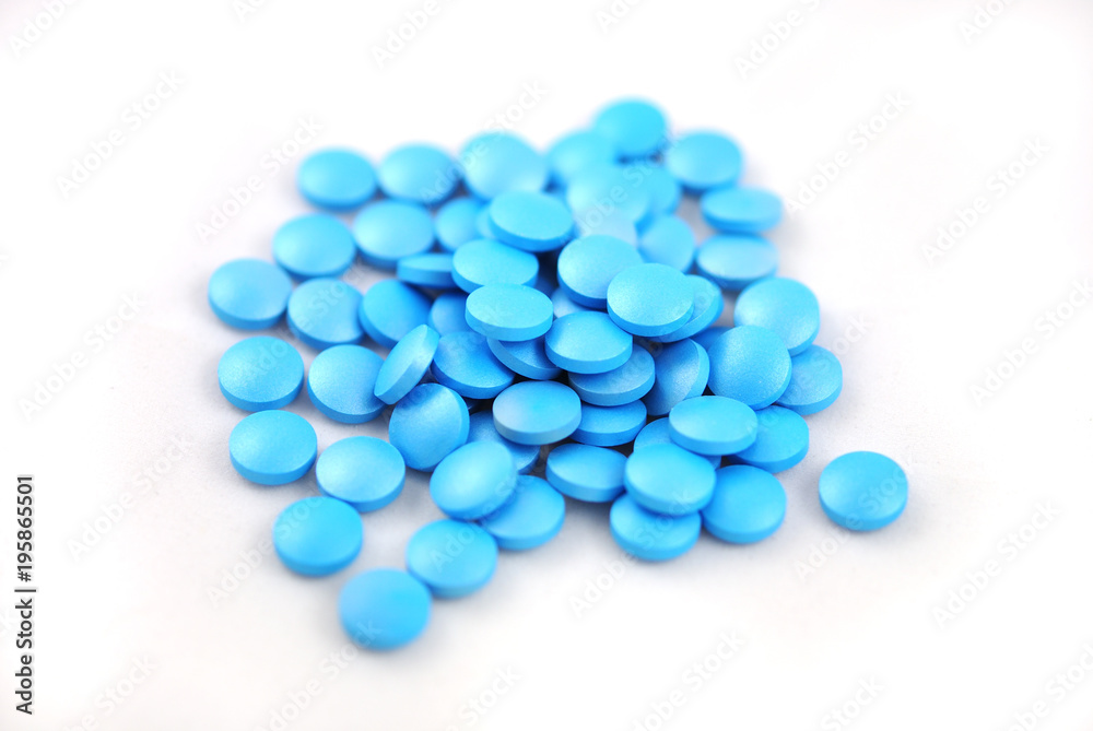 Bright blue round tablets closeup on white background