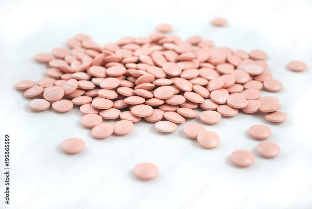 Light pink tablets closeup on white background Light pink tablets closeup on white background