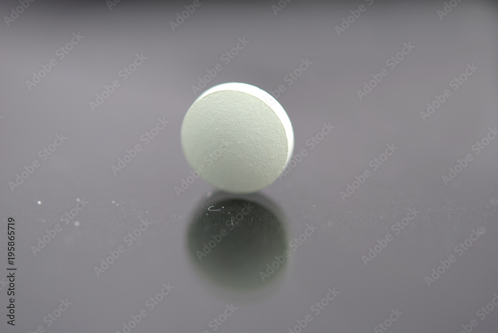 Alone round tablet with reflection closeup isolated Alone round tablet with reflection closeup isolated