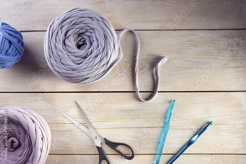 Knitting wool and knitting tools on wooden background.