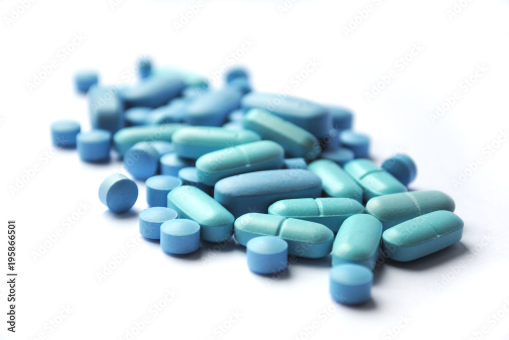 Blue round and oval tablets closeup on white background Blue round and oval tablets closeup on white background