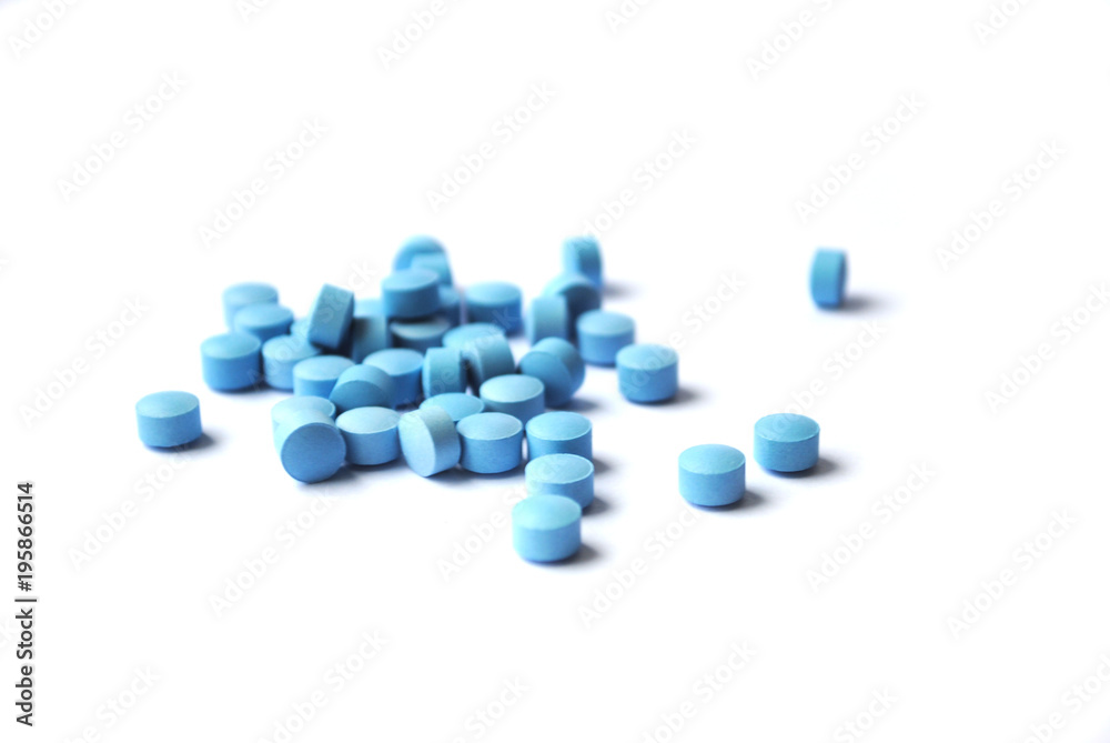 Small blue roynd tablets closeup on white background Small blue roynd tablets closeup on white background