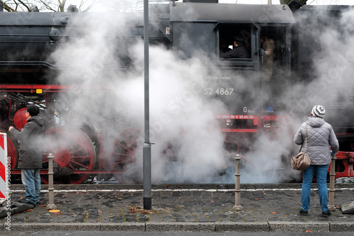 Pedestrians examining a historic steam train in Frankfurt, Germany
