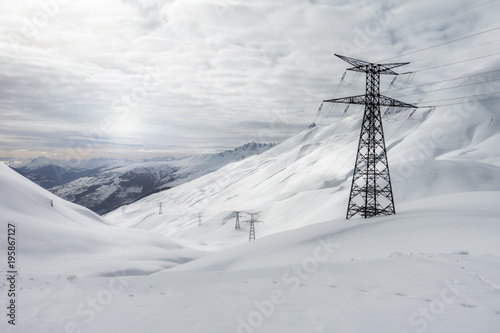 white winter landscape in snowy mountains, high voltage towers © Federico Rostagno