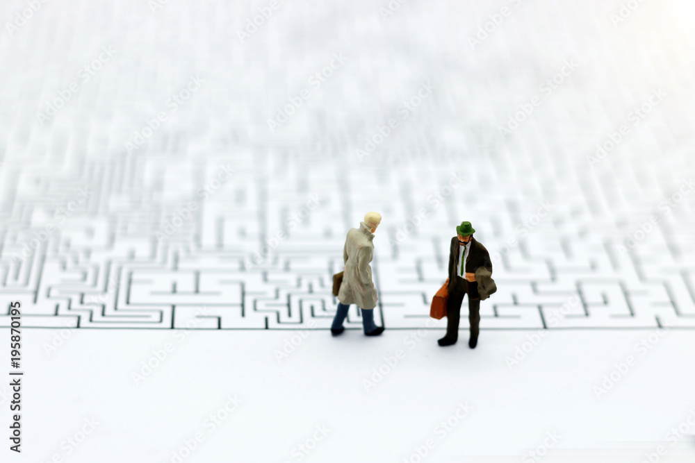 Miniature people: Businessman standing on start of maze. Concepts of finding a solution, problem solving and challenge. Miniature people: Businessman standing on start of maze. Concepts of finding a solution, problem solving and challenge.