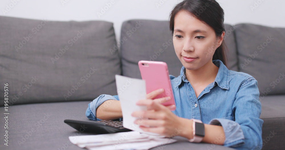 Housewife using cellphone to take photo on receipt at home Housewife using cellphone to take photo on receipt at home