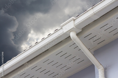 Quadro su tela white plastic rain gutter and dark sky