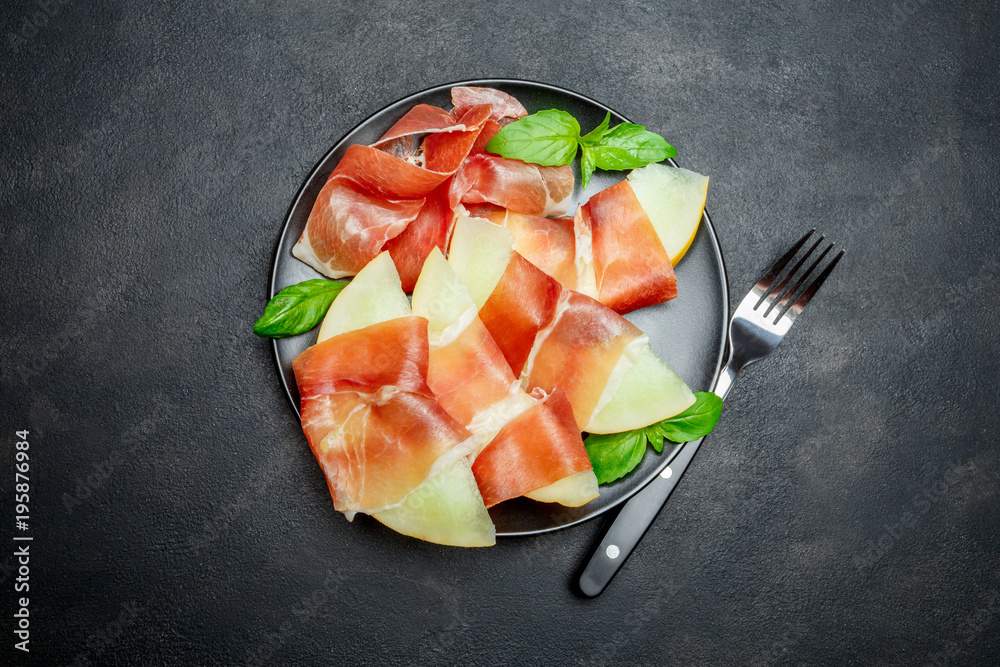 italian food with melon and prosciutto on the plate