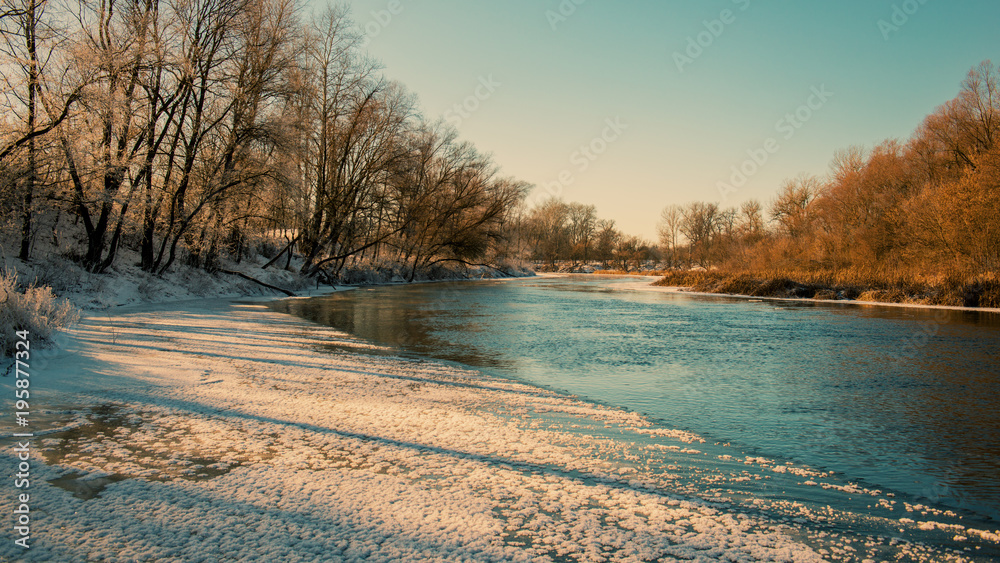 Freezing river and deciduous forest.
