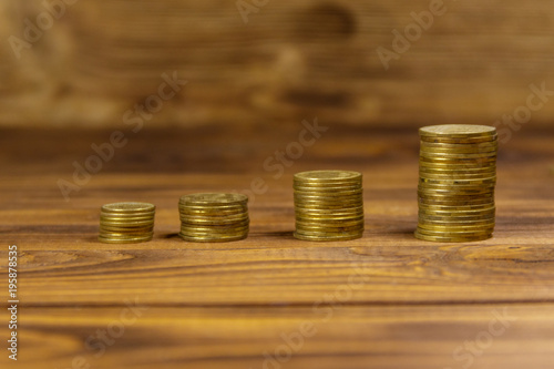 Stacks of golden coins on wooden background