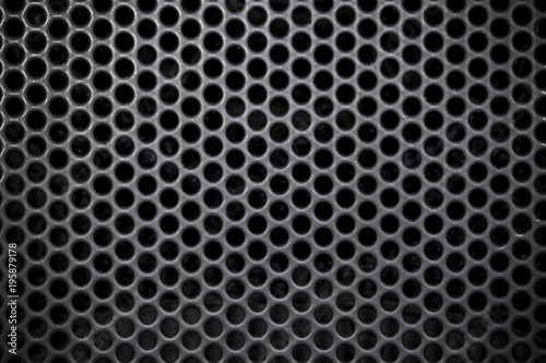 photo of a close-up of a musical column hidden behind a grid with a pattern of rhythmically arranged holes, background image