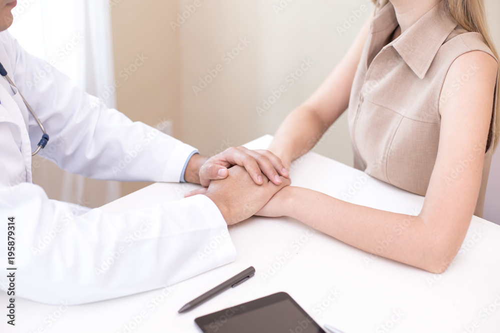 Doctor working at hospital. Doctor try to treat woman for any problem. He holding her hand.