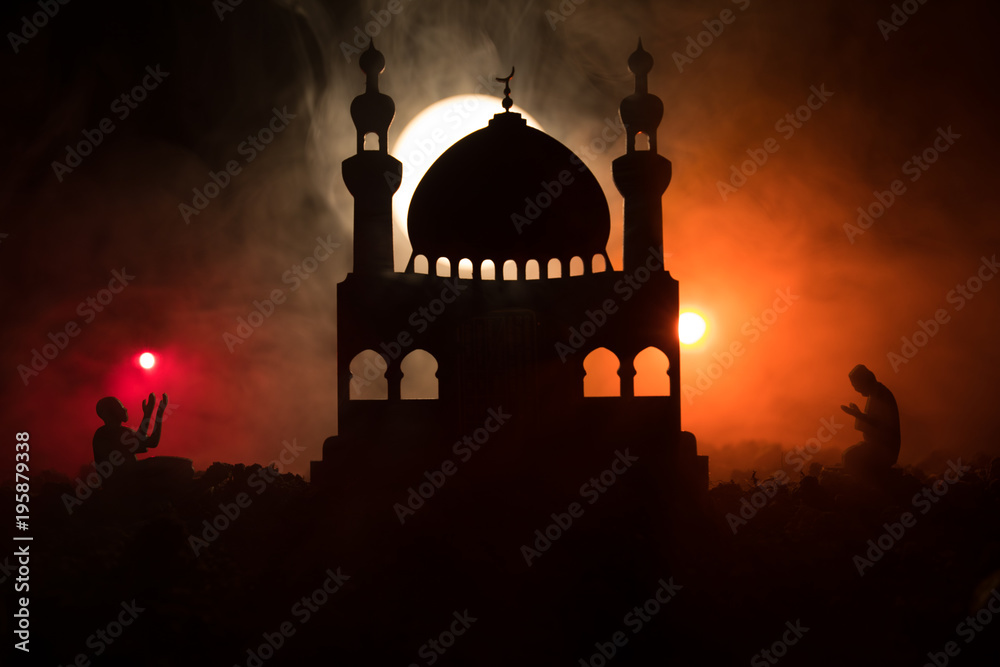 Silhouette of mosque building on toned foggy background. Ramadan Kareem background. Mosque at sunset. Praying people. Selective focus