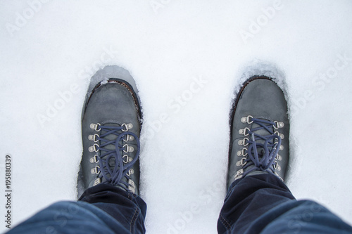 a man in warm winter boots stands in the snow
