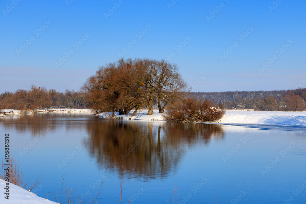 Reflections of trees on winter river at sunset Reflections of trees on winter river at sunset