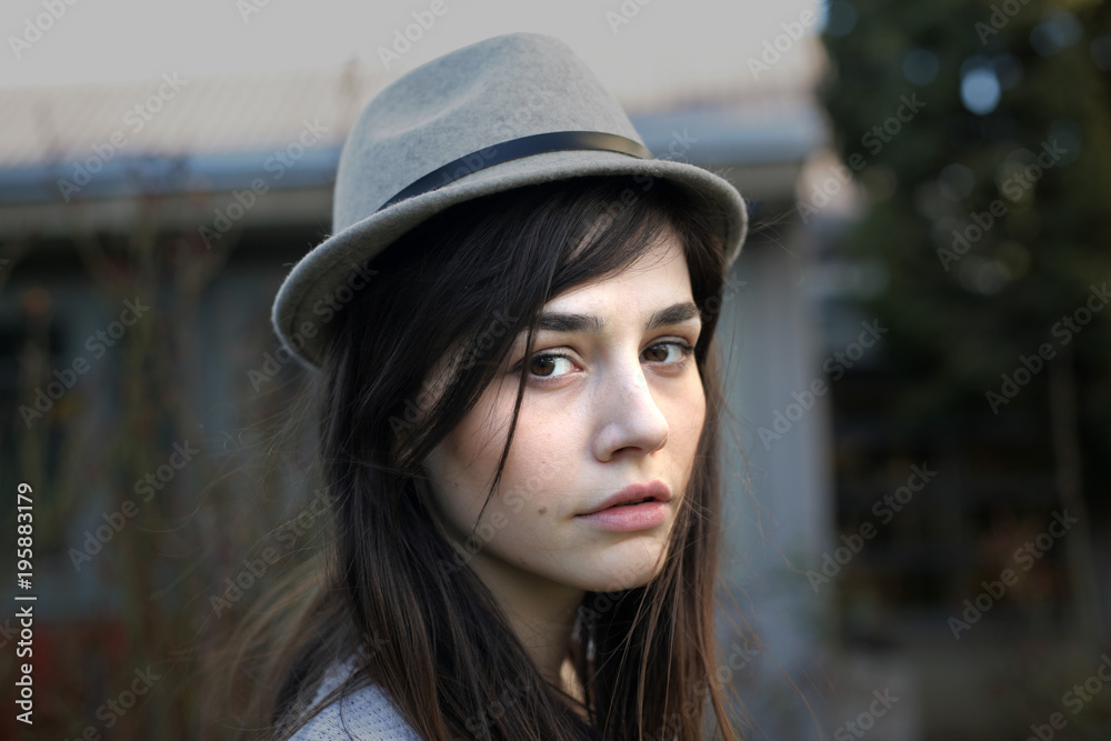 Portrait of a young woman with hat; close up, selective focus background. Portrait of a young woman with hat; close up, selective focus background.