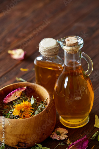 SPA concept: composition of spa treatment with natural sea salt, aromatic oil and flowers on wooden background