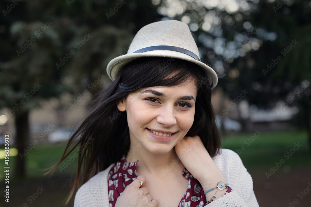 Portrait of a young woman with hat; happy girl with hat is smiling and looking at camera. Portrait of a young woman with hat; happy girl with hat is smiling and looking at camera.