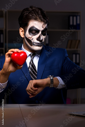 Businessman with scary face mask working late in office © Elnur