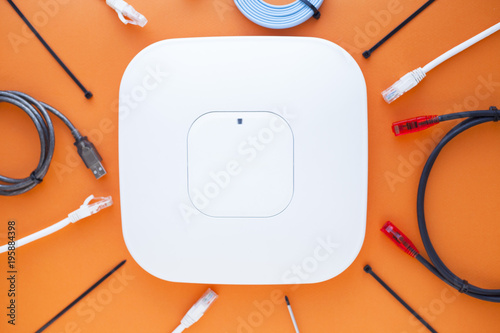 Corporate network concept. Set of ethernet switches, access points, cables, connectors, laptops on the orange background. Top view. Space for a text. Close up.