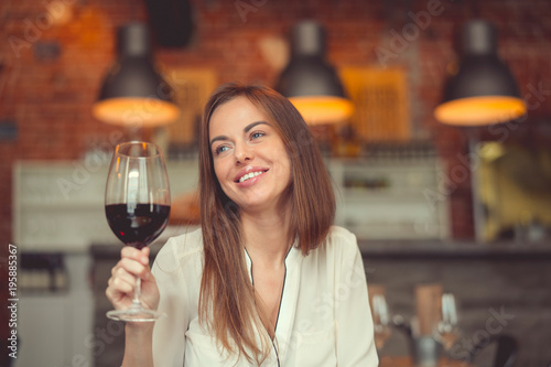 Smiling girl with a glass of red wine