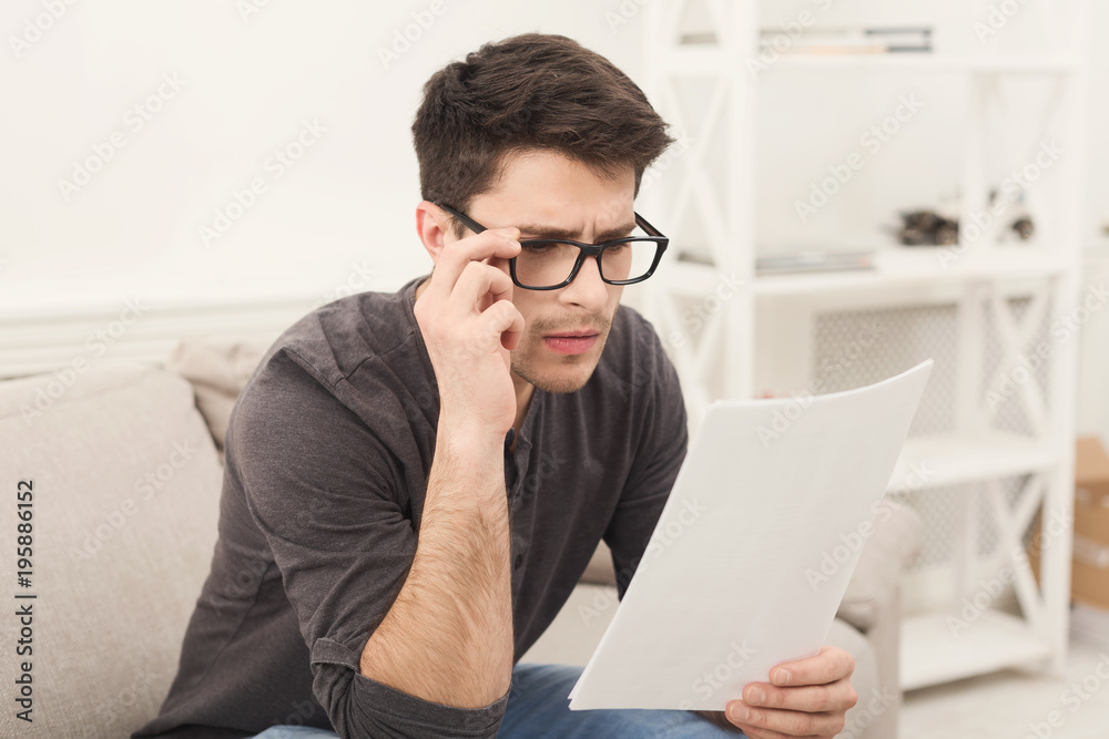 Young tired businessman reading report at home Young tired businessman reading report at home