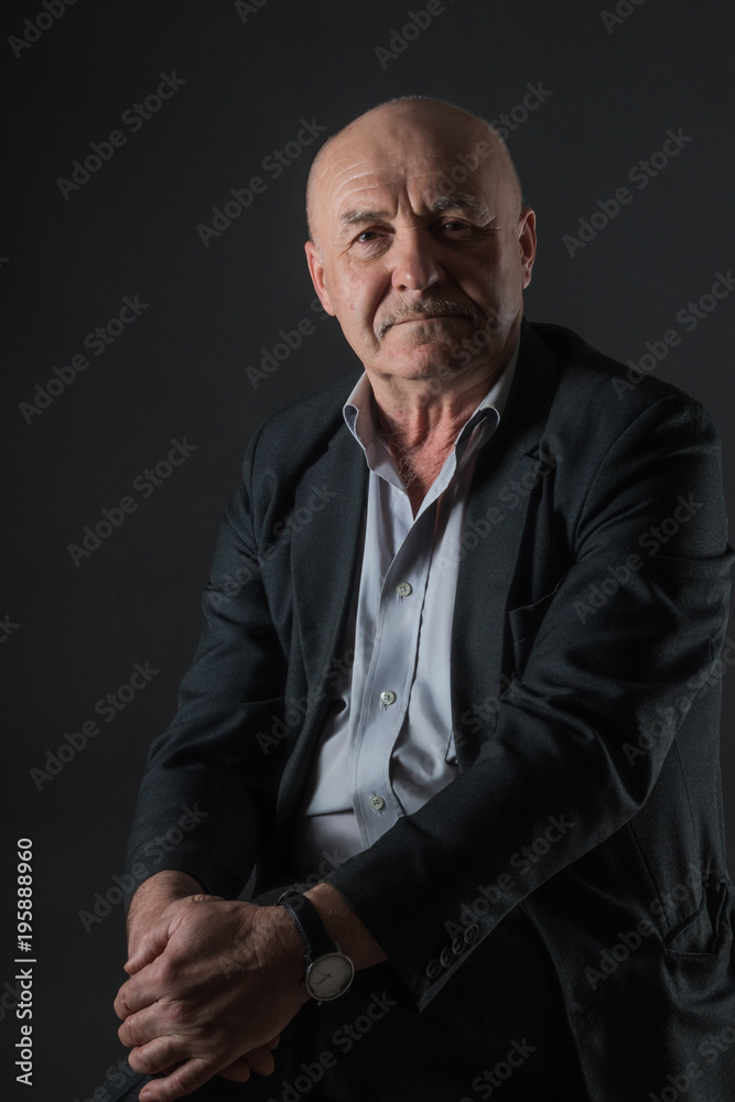 Fototapeta premium Podeszłym wieku pozytywny biznesmen płci męskiej na ciemnym tle