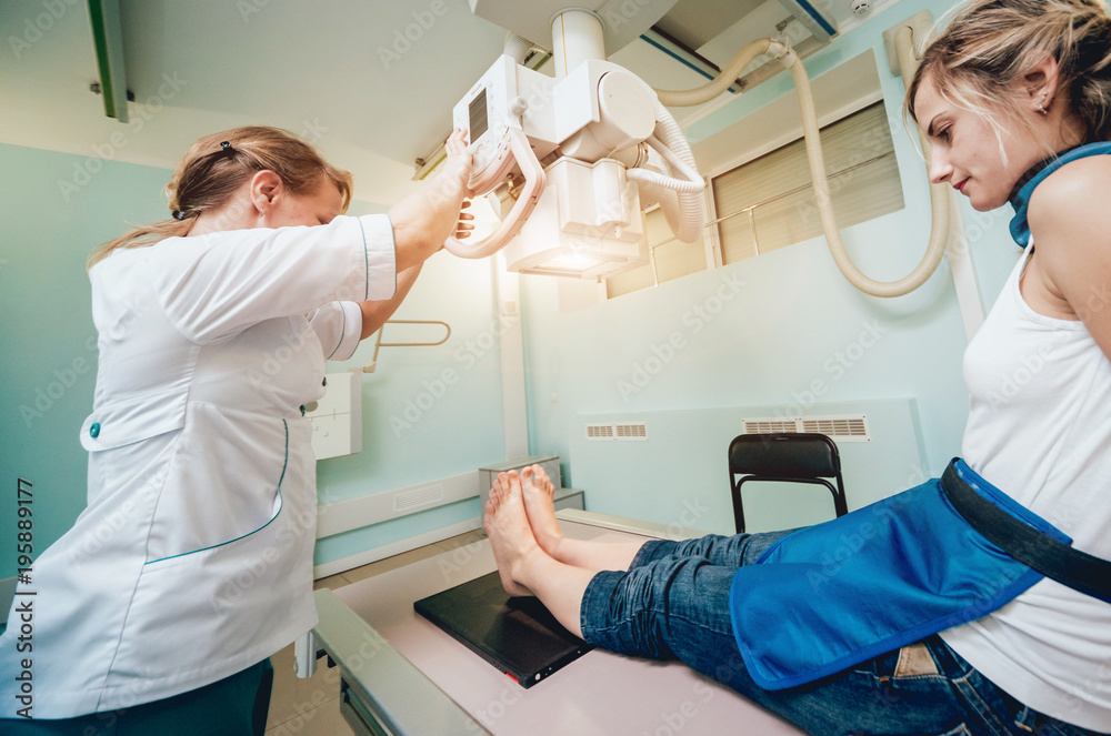 Radiologist and patient in a x-ray room. Classic ceiling-mounted x-ray system. Radiologist and patient in a x-ray room. Classic ceiling-mounted x-ray system.