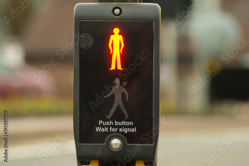 traffic light push button wait for signal with bright illumination of red man at pedestrian crossing symbolising lock down and don't go out photo