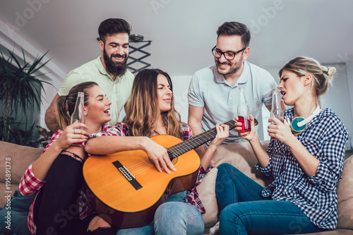 Group of happy young friends having fun and drinking beer in home interior © Mediteraneo