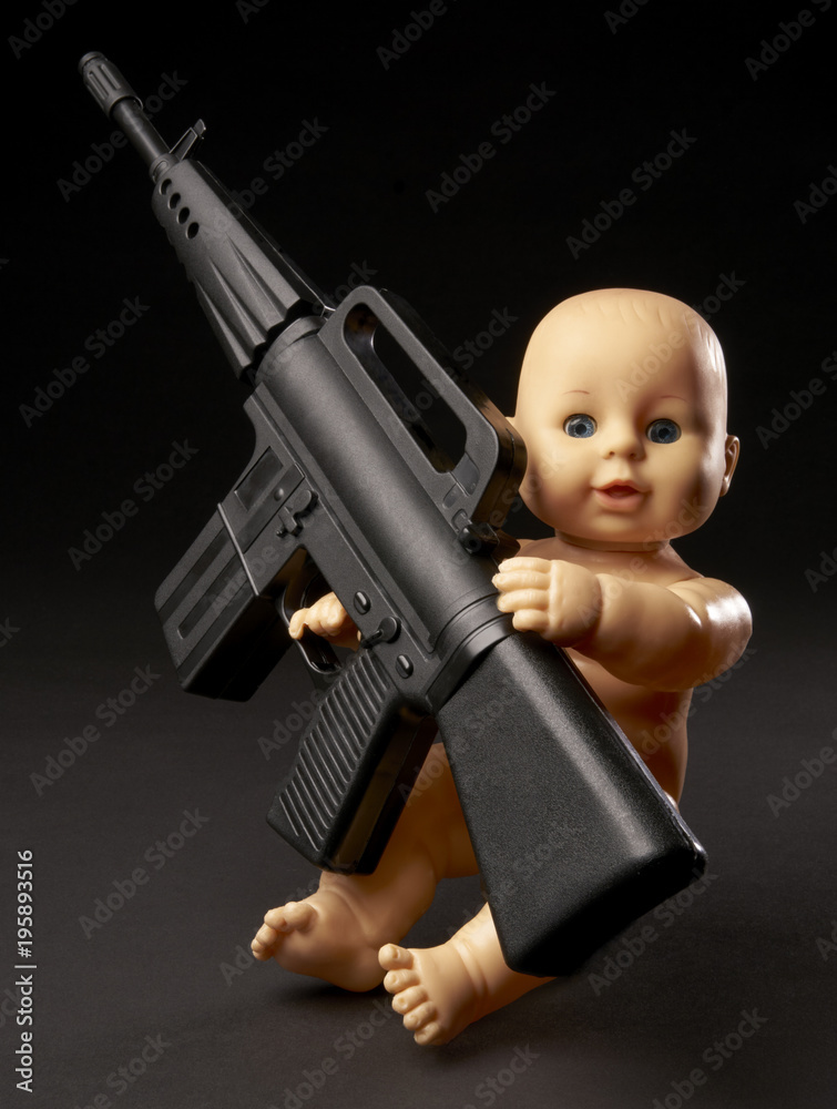 Happy baby with his assault weapon. Gun control concept. Isolated on black  background. With copy space text. Studio Shot. Stock Photo | Adobe Stock