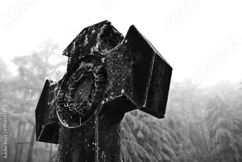 Graves with crosses at winter cemetery in black and white image photo