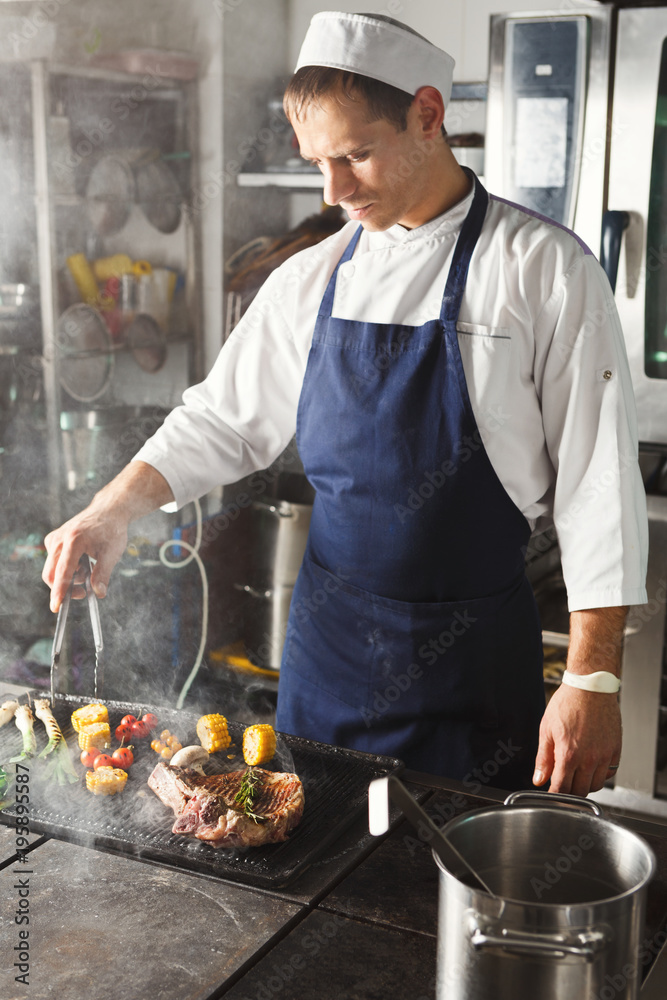 Chef cooking juicy beef steak at restaurant kitchen Stock Photo Adobe