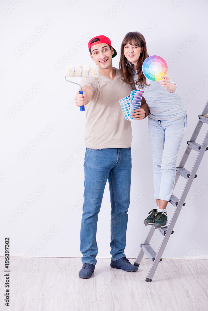 Young family doing renovation at home - painting walls Young family doing renovation at home - painting walls