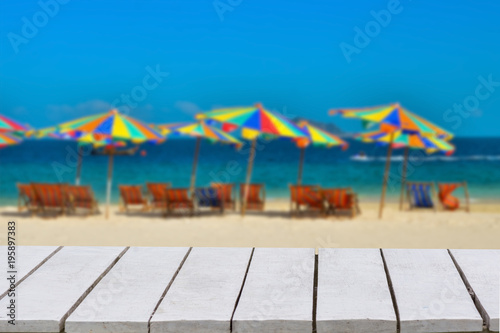blue background with selective focus. has a bokeh on a white wooden floor. Empty table empty space wooden table empty Wooden floor After blurred blue sea umbrella sky