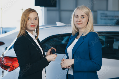 Woman receiving car keys from a dealer photo