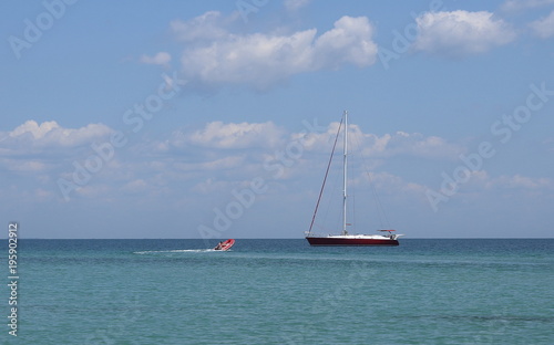little boat and red yacht in the sea during the vacation