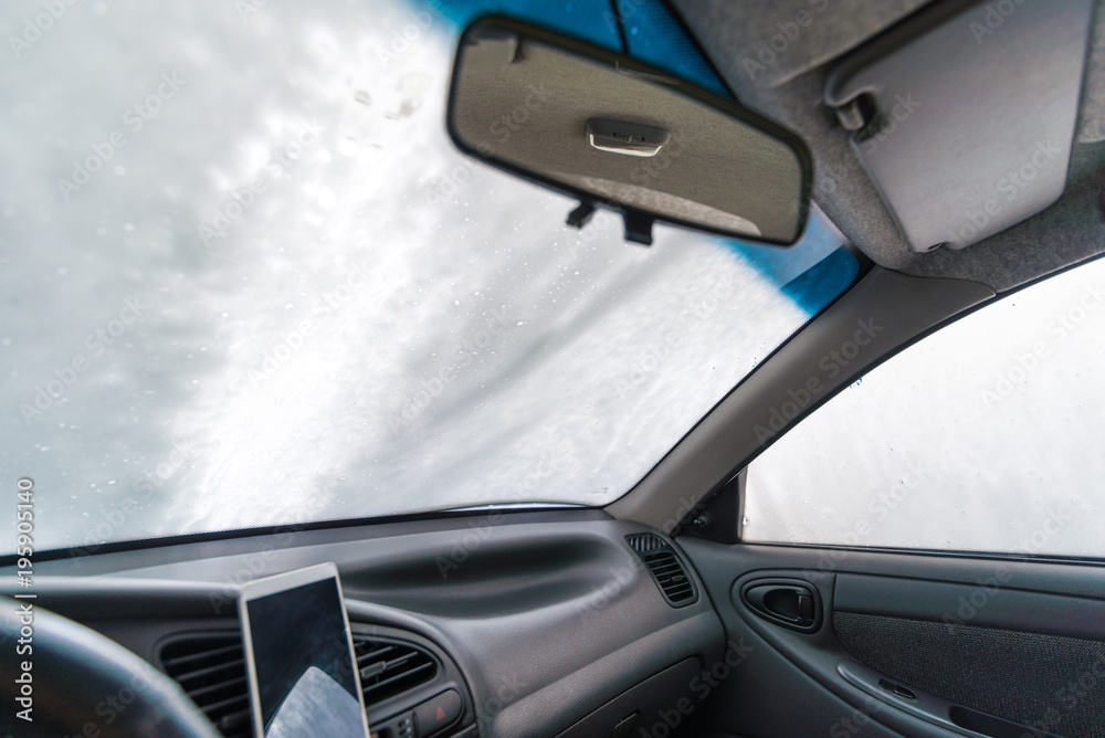 windshield of car in soap. car wash concept. view from inside
