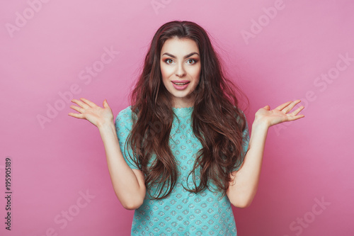 Horizontal portrait of cheerful surprised woman with appealing smile, having long hair isolated over pink background. Beautiful female showing her pleasant emotions. People Beauty Fashion Lifestyle