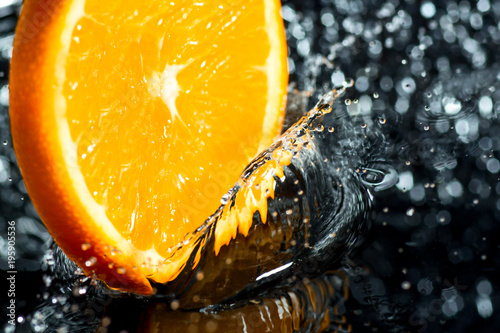 Fototapeta Naklejka Na Ścianę i Meble -  orange ring with splashes of water, a fruit and vitamin splash
