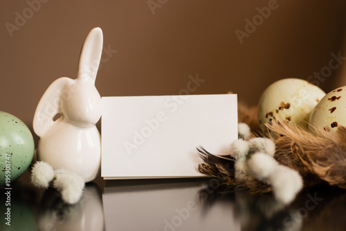 Small white rabbit figurine with easter eggs photo