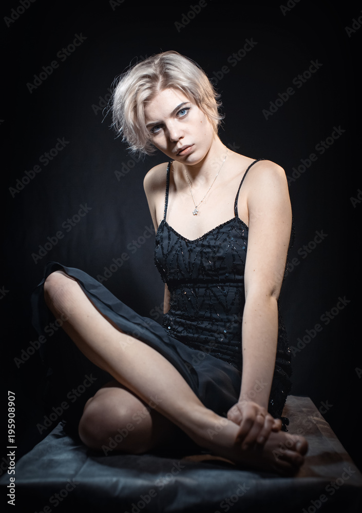 Beautiful girl sitting in black dress