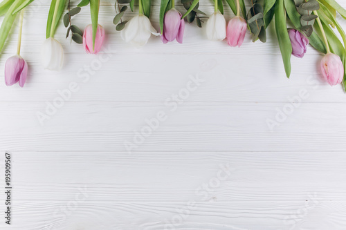 Fototapeta Naklejka Na Ścianę i Meble -  Violet and white tulips on a wooden background.