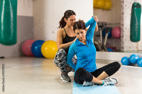 Принти на полотні Mid-aged woman stretching out with the help of a physical therapist