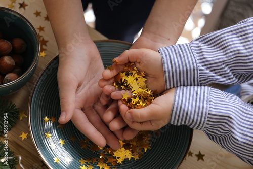 boys take a gold star confetti in hands in winter decorations