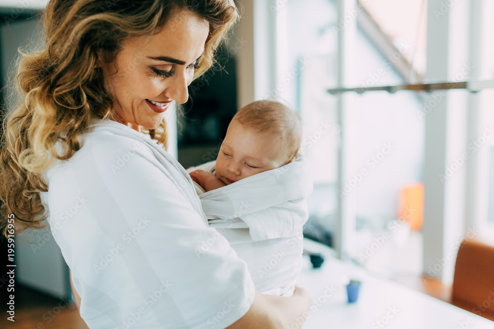 Hübsche Mutter schaut stolz auf ihren kleinen schlafenden Sohn Hübsche Mutter schaut stolz auf ihren kleinen schlafenden Sohn