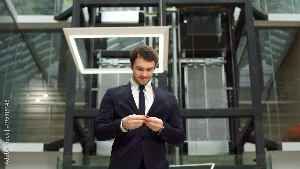 Golden Bitcoin in hand with businessman blurred on background. Golden Bitcoin in hand with businessman blurred on background.
